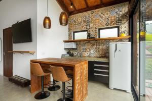 a kitchen with a wooden table and a refrigerator at Lobo Gris - Recanto idílico com vista espetacular in Itatiaia