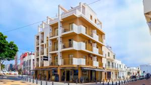 a yellow and white building on a city street at Hostal Dinamarca in San Antonio