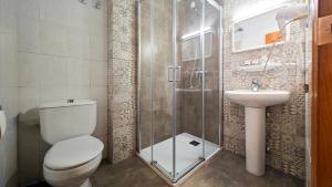 a bathroom with a shower and a toilet and a sink at Hostal Dinamarca in San Antonio +81 photos