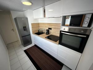 a white kitchen with a sink and a microwave at La trinquette in Saint-Gilles-Croix-de-Vie