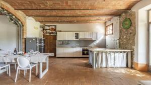 eine Küche mit weißen Tischen und weißen Schränken in der Unterkunft Sant'Alberto in Castiglione dʼOrcia