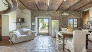 eine Küche und ein Wohnzimmer mit einem Tisch und einem Sofa in der Unterkunft Sant'Alberto in Castiglione dʼOrcia
