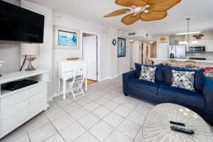 Una sala de estar con un sofá azul y un televisor en Island Princess 501 - Shoreline Shindig, en Fort Walton Beach