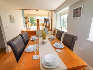 a dining room table with chairs and a long wooden table at Bryn Golau in Llangollen