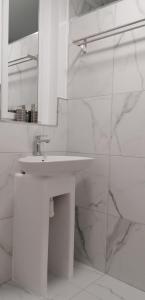 een witte badkamer met een wastafel en een spiegel bij Los Geranios n.25 in Icod de los Vinos