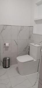 een witte badkamer met een toilet en een rol toiletpapier bij Los Geranios n.25 in Icod de los Vinos
