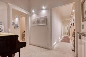 un couloir avec une porte blanche et un piano dans l'établissement Your House Rooms, à Gênes