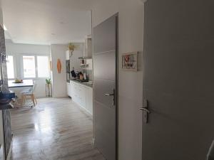a kitchen with a door open to a kitchen with a table at L'appart' Centre ville 3 chambres in Rethel +5 photos