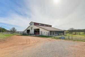 PurdyにあるPet-Friendly Purdy Home with Horse Stables and Trails!の未舗装の道路に建つ赤いドアの付いた白い納屋