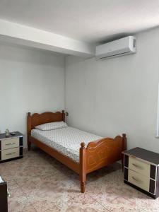a bedroom with two beds and a air conditioner on the wall at Hillside Haven in Durrës