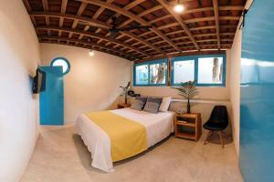 a bedroom with a bed and a tv and windows at Casa Cocos Bungalow en Playa La Ropa Zihua con AC in Zihuatanejo