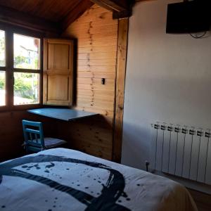 a bedroom with a bed and a desk and a window at Apartamentos caravia, cachucho-casa in Duesos