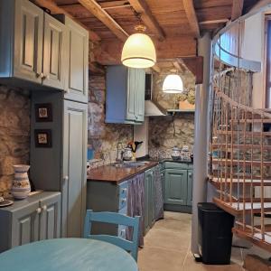 a kitchen with blue cabinets and a staircase at Apartamentos caravia, cachucho-casa in Duesos