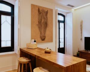 a room with a table with a picture of a horse on the wall at A Casa Brava in Santarém