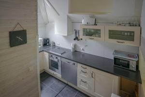 uma cozinha com armários brancos e um balcão preto em FH Gestiefelter Kater am See im hessischen Bergland em Kirchheim