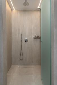a bathroom with a shower with a phone on the wall at V&C Paradise Apartments in Rodakino