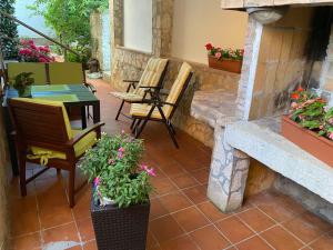 a patio with a table and chairs and plants at Dora in Funtana