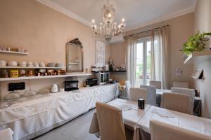 une salle à manger avec des tables et des chaises ainsi qu'un lustre dans l'établissement Your House Rooms, à Gênes