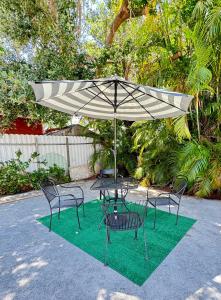 un groupe de chaises et un parasol sur une parcelle d'herbe dans l'établissement Oasis Wynwood, à Miami