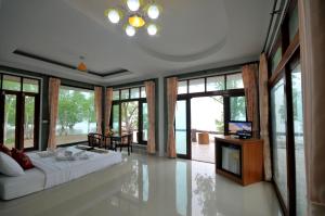 a bedroom with a large white bed and large windows at I Talay Lanta in Ko Lanta
