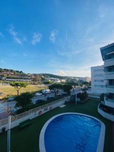 - une vue sur la piscine depuis un bâtiment dans l'établissement Exclusivo piso con terraza al lado de la playa, à Lloret de Mar