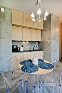 stół jadalny z krzesłami i kuchnia w obiekcie Wygodny apartament w Pucku w mieście Puck