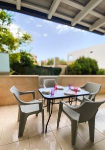 a table and chairs on a balcony with drinks on it at Olive Garden by Golden Host in Nea Moudania