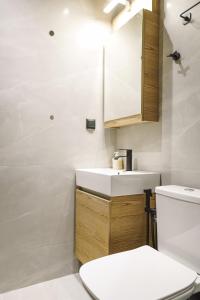 a bathroom with a white sink and a toilet at Olive Garden by Golden Host in Nea Moudania