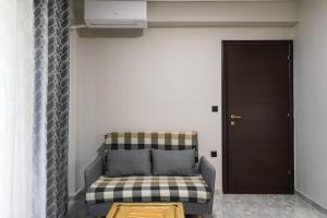 a couch sitting in a room next to a door at Olive Garden by Golden Host in Nea Moudania