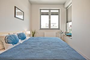 sypialnia z dużym łóżkiem i niebieskim kocem w obiekcie Wygodny apartament w Pucku w mieście Puck +20 zdjęć
