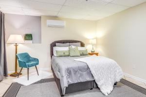 Un dormitorio con una cama y una silla azul. en Cozy Jonesboro Studio with Patio about 22 Mi to Atlanta!, en Jonesboro