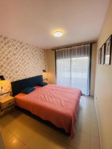 - une chambre avec un grand lit et une fenêtre dans l'établissement Exclusivo piso con terraza al lado de la playa, à Lloret de Mar