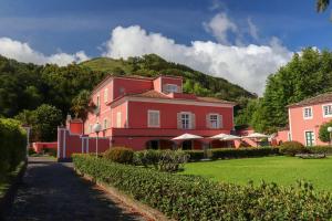 a red building with a mountain in the background at Solar de Lalém in Maia