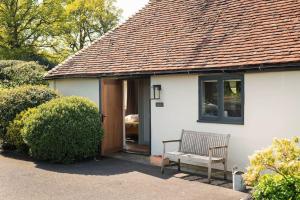 a white house with a bench in front of a door at Winters Farm Cottage in Mayfield