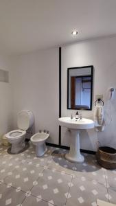 a bathroom with two toilets and a sink and a mirror at La Botica de 1852 Hotel in Chascomús +52 photos