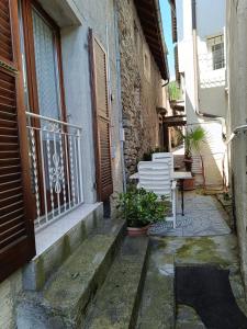 un portico con 2 sedie bianche e un balcone di Casa Chiara a Intragna (Centovalli)