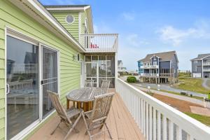 a deck with chairs and a table on a house at Lowe Tide in North Topsail Beach