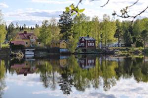 un reflejo de las casas en un cuerpo de agua en Sweden Slow Living, en Gösunda