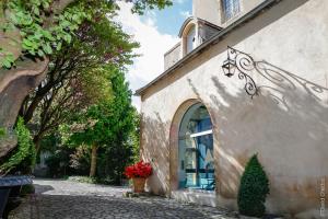 un edificio con una ventana y un jarrón de flores en La Cour Berbisey - Teritoria en Dijon