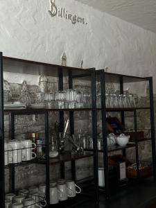 a shelf with glasses and other items on it at Dillinger Hof in Dillingen an der Donau +13 photos