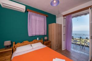 a bedroom with an orange bed and a balcony at Elena Studios in Athani