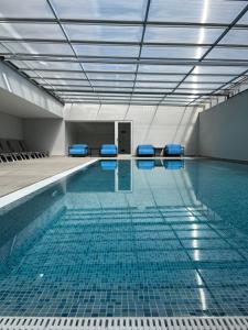 une piscine avec des chaises bleues dans une chambre dans l'établissement Sesimbra Blue Paradise, à Sesimbra 13 autres photos