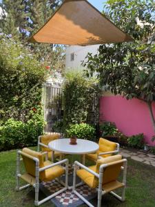 einen Tisch und Stühle unter einem Schirm in der Unterkunft Villa San José in Arequipa