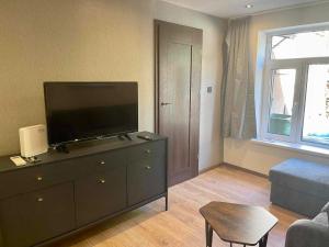 a living room with a flat screen tv on a dresser at City apartment in Pärnu