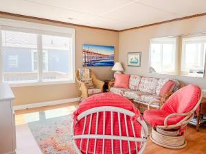 a living room with a red couch and chairs at Lungomare in Surf City