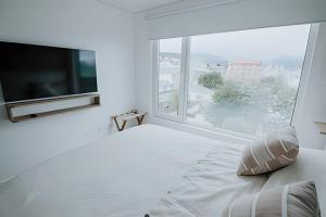ein weißes Schlafzimmer mit einem großen Fenster und einem Bett in der Unterkunft Aunaisin- Austral - 306 - Vista increible in Ushuaia