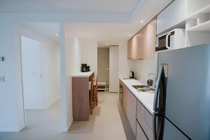 eine Küche mit weißen Arbeitsflächen und einem schwarzen Kühlschrank in der Unterkunft Aunaisin- Austral - 306 - Vista increible in Ushuaia