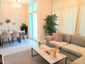 uma sala de estar com um sofá e uma mesa em Damac Hills 2 Retreat- Tranquil Luxe, Beyond City with waterpark no Dubai
