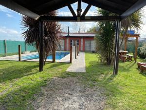 a house with a swimming pool next to the ocean at El Quincho in San Miguel del Monte