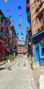 una strada vuota con ombrelli colorati appesi agli edifici di Appartement Chic & Baroque 5 min centre ville et Bord de Vienne a Limoges